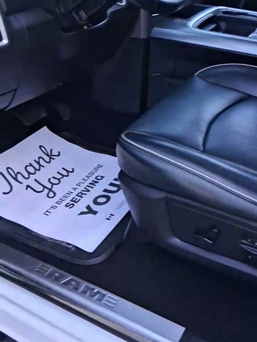 Finished Ram cab — black leather and the shop's thank-you card on the door sill
